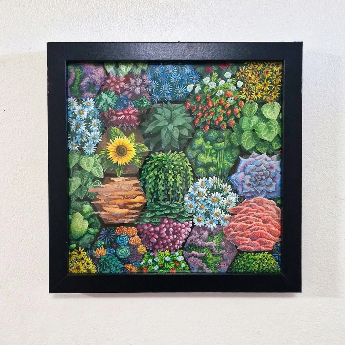 a painting of a honeycomb patterned vertical garden. the garden includes mushrooms, sunflowers, strawberries, daisies, succulents, grapes, moss etc. the painting is framed in a modern black square frame.
